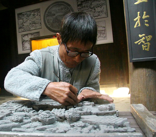 A master carver doing on a brick carving work